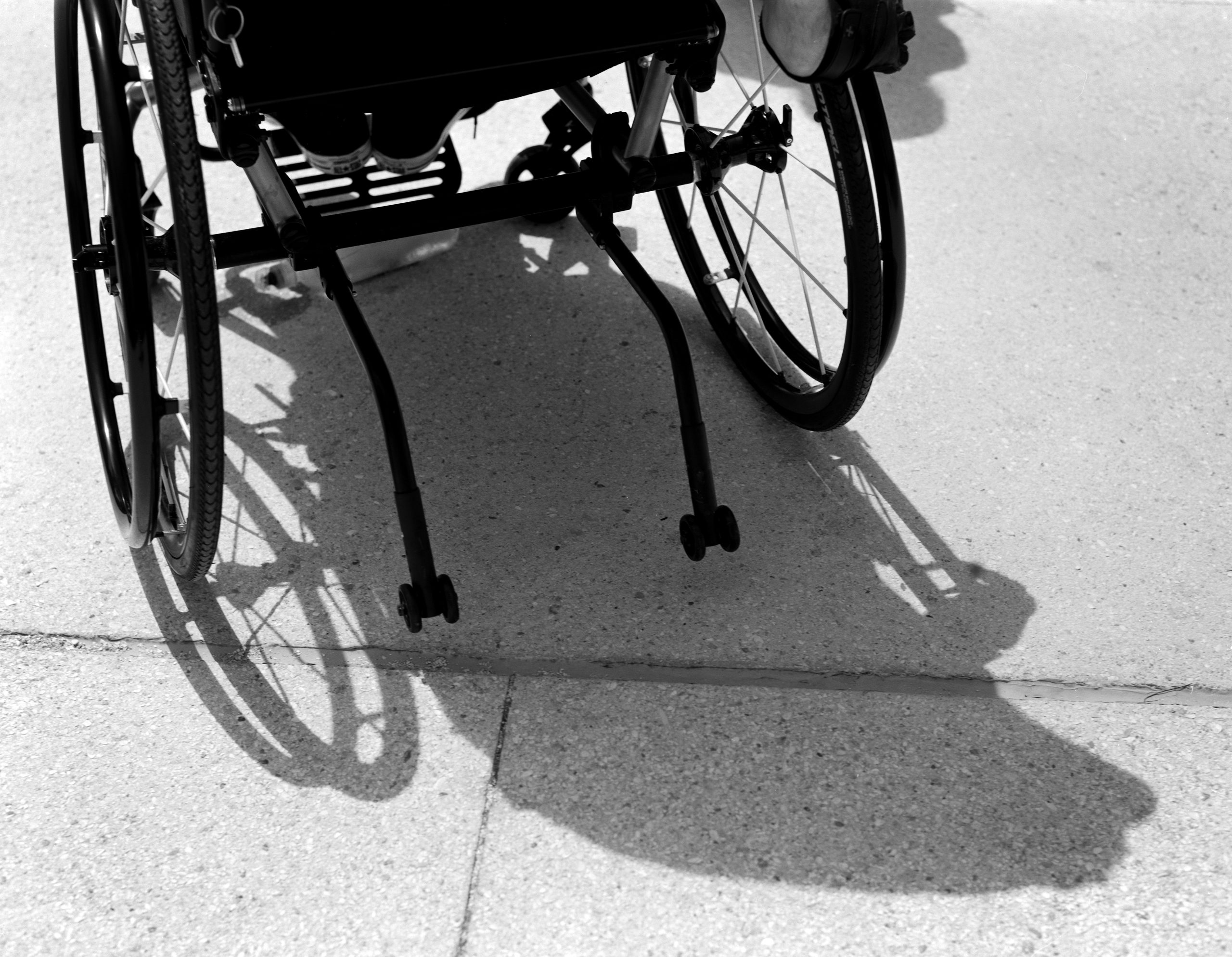 Detail of a wheelchair with shadow. Captured on film